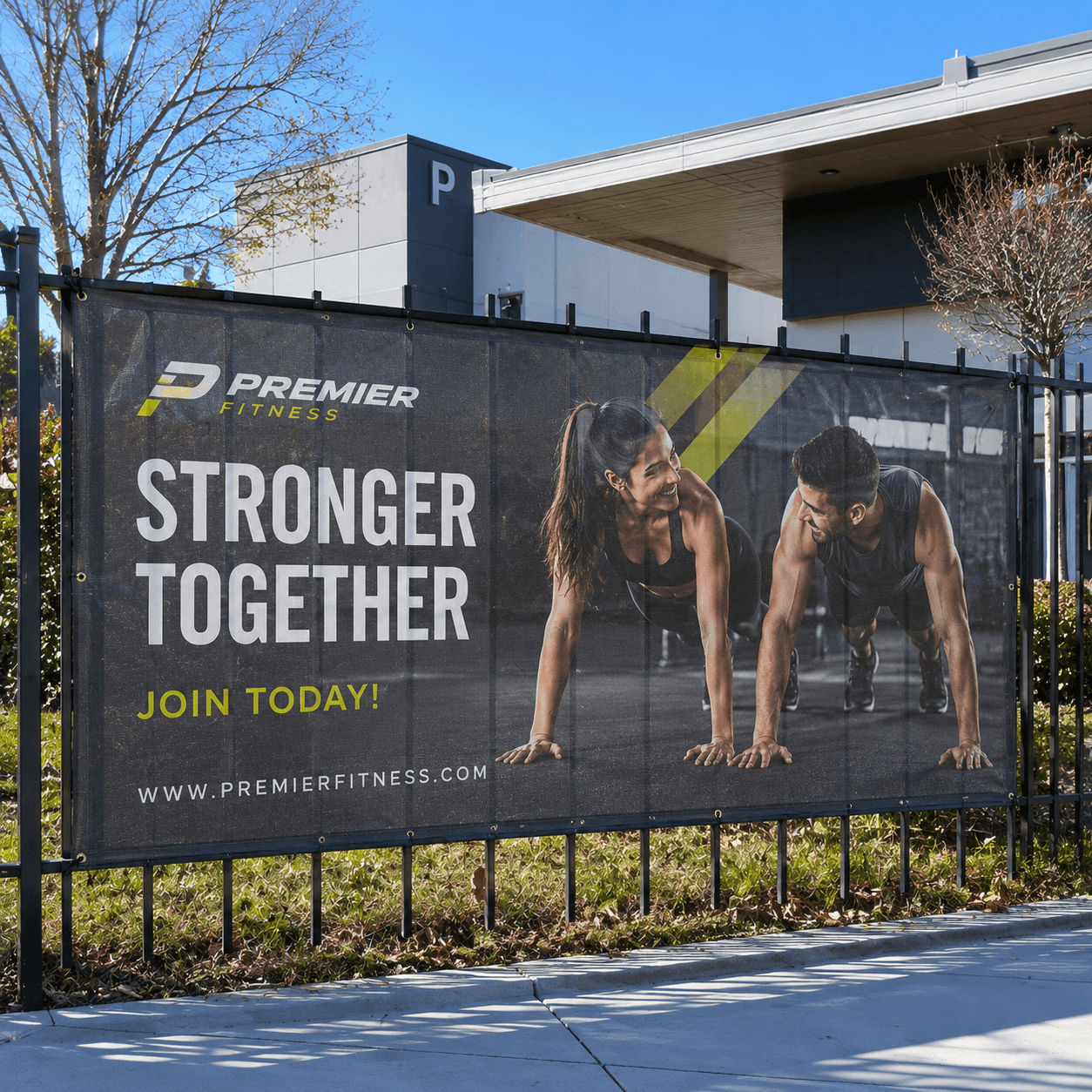 Custom mesh banner installed on outdoor fence for business advertising
