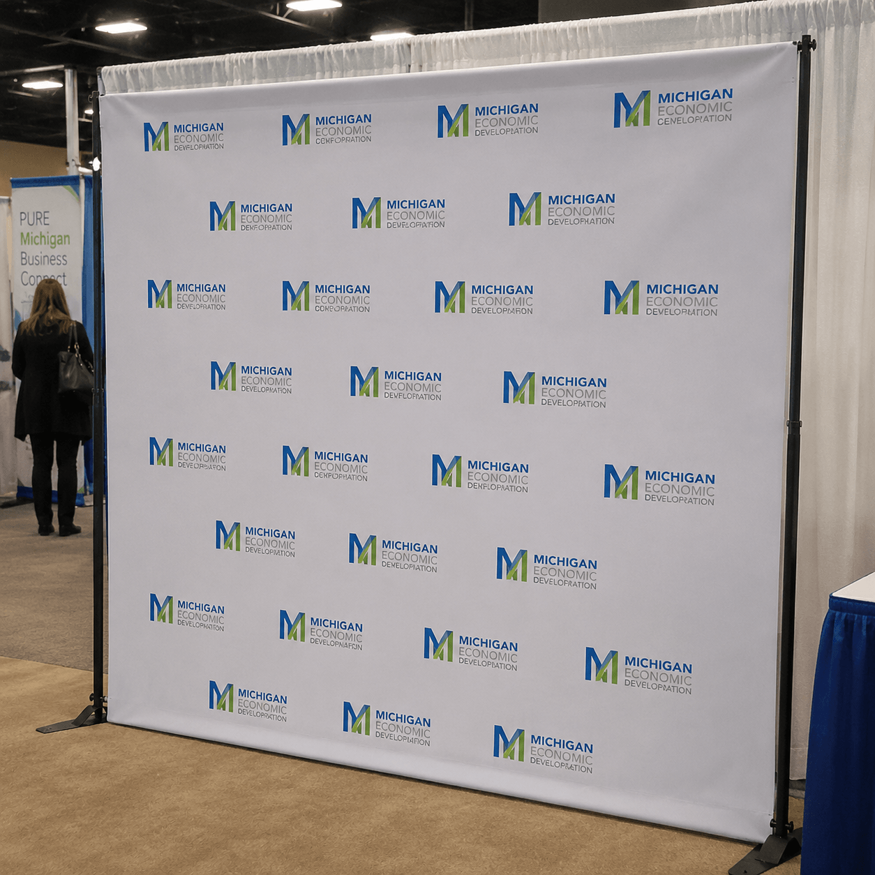 Branded step and repeat banner displayed at trade show media wall